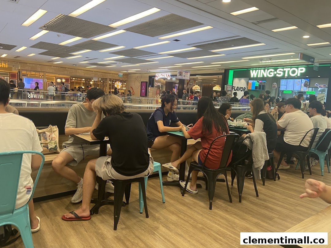 Diners enjoying meals in a bustling food court with Wingstop visible in the background.
