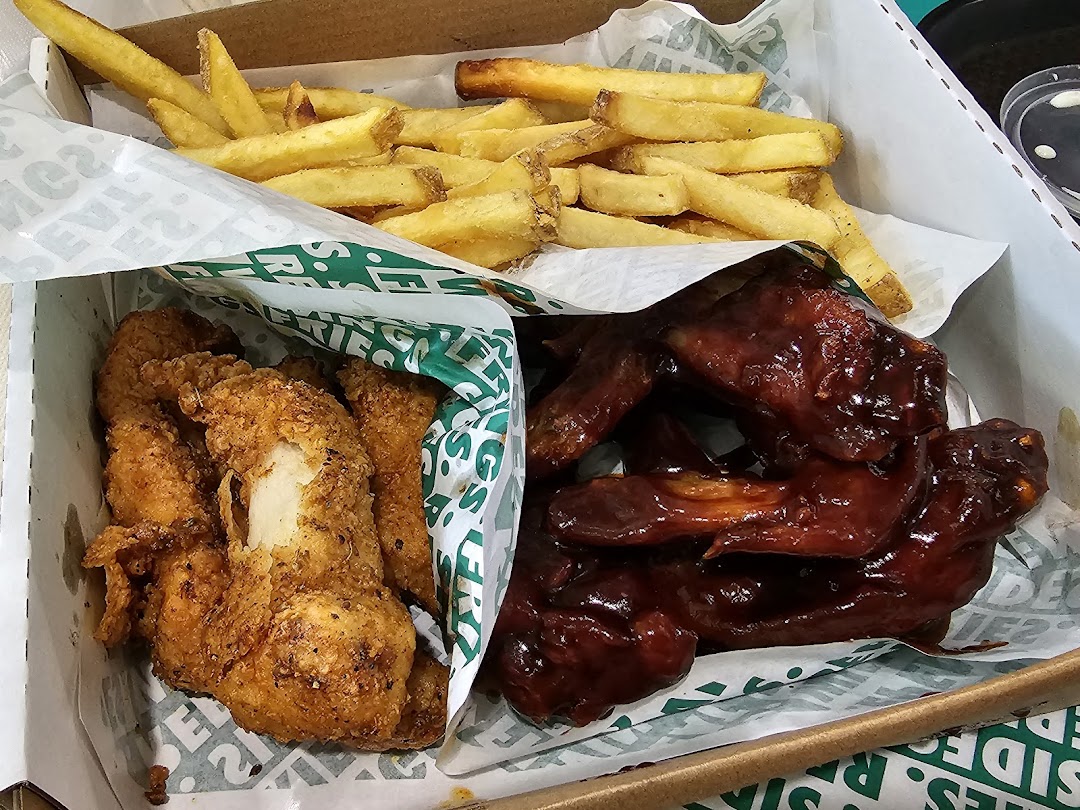 A Wingstop box filled with crispy chicken tenders, saucy chicken wings, and golden fries.