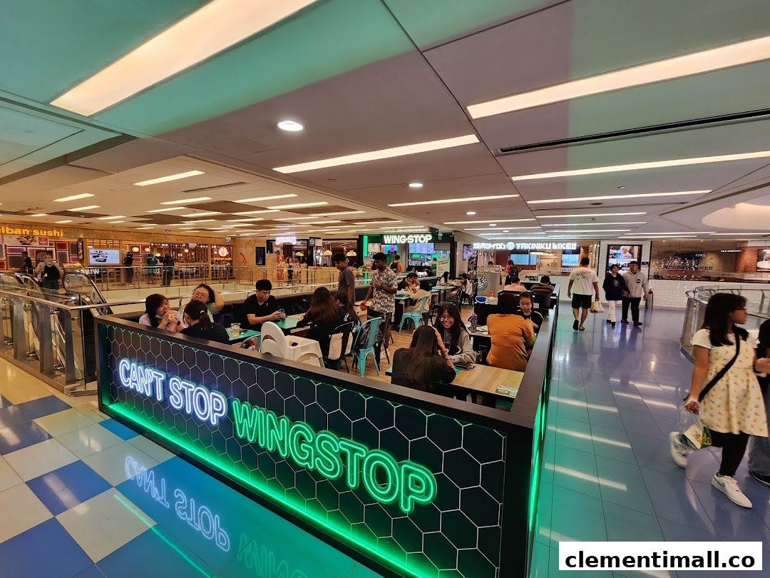 Wingstop dining area in a bustling mall food court with customers enjoying their meals.