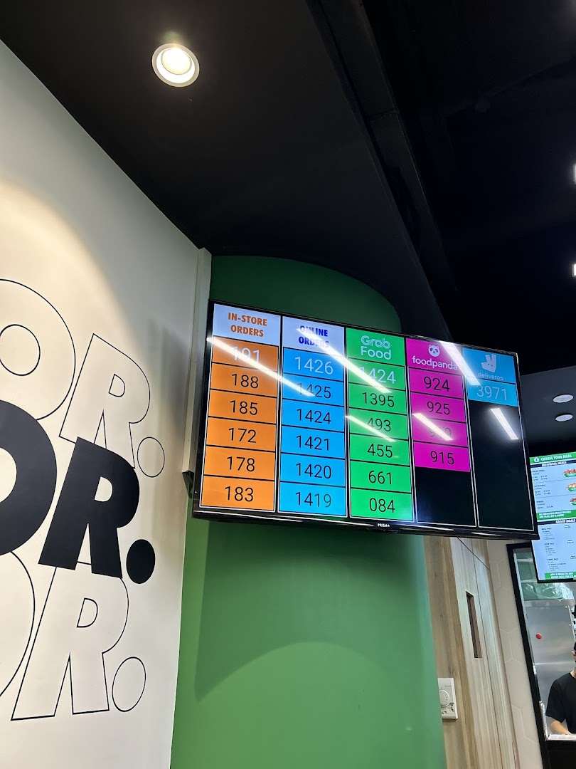 A digital screen inside Wingstop displaying current order numbers for in-store and delivery platforms.