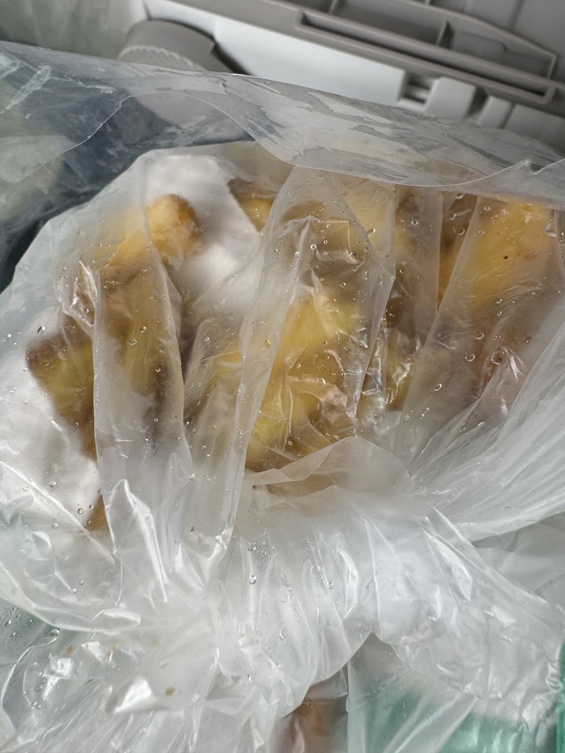 Frozen potato wedges or similar food items stored in a clear plastic bag.