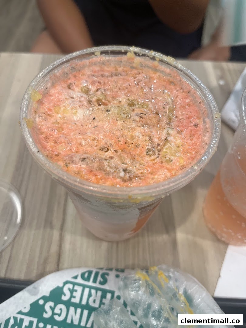 A close-up of a vibrant, foamy beverage in a clear cup, likely from Wingstop.