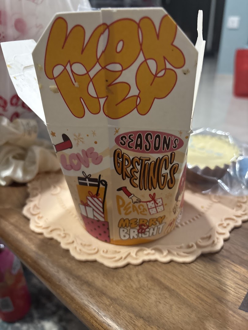 A WOK HEY noodle box featuring festive 'Season's Greetings' and 'Merry Bright' designs.