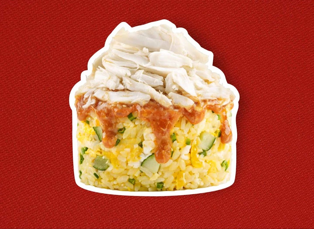 A vibrant image of fried rice topped with generous crab meat and a savory sauce.