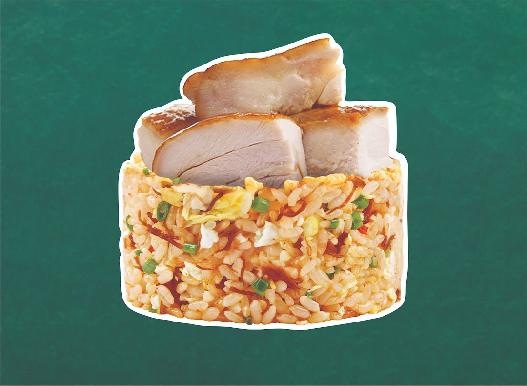 A close-up of wok-fried rice topped with succulent pieces of roasted meat against a green background.