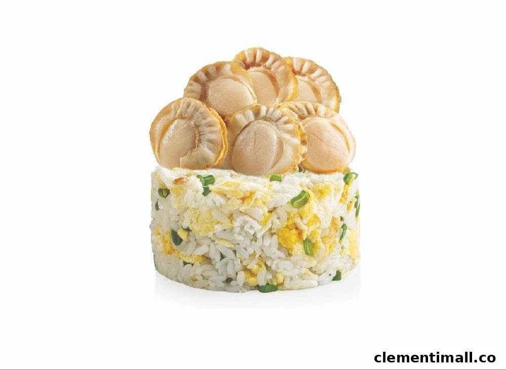 A cylindrical serving of fried rice topped with several plump scallops and garnished with spring onions.