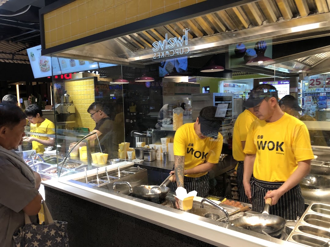 Chefs at WOK HEY prepare fresh stir-fried noodles and rice dishes in an open kitchen.
