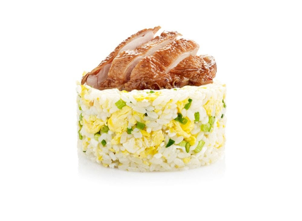 A cylindrical serving of fried rice with egg and spring onions, topped with sliced roasted meat.