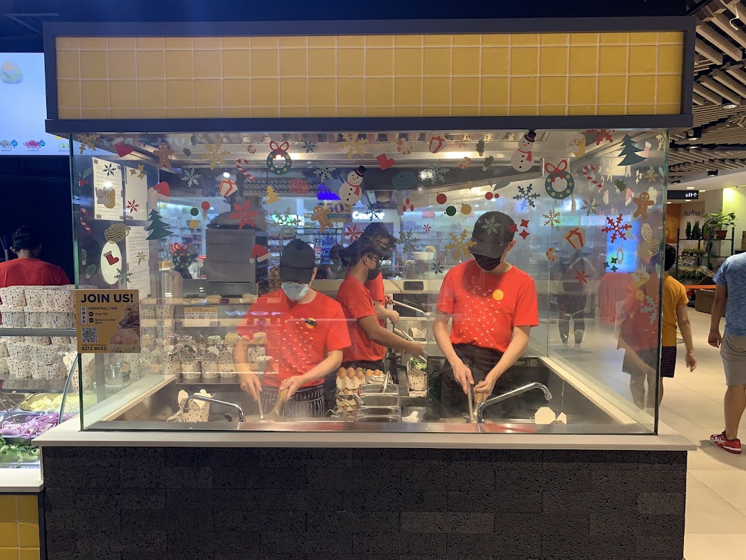 Staff prepare fresh stir-fried dishes in a glass-enclosed kitchen, decorated for the holidays.