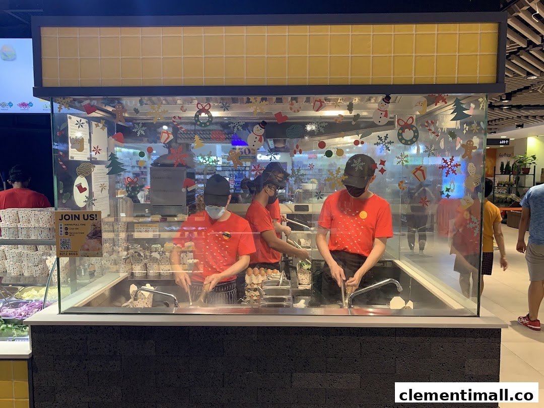 Staff prepare fresh stir-fried dishes in a glass-enclosed kitchen, decorated for the holidays.