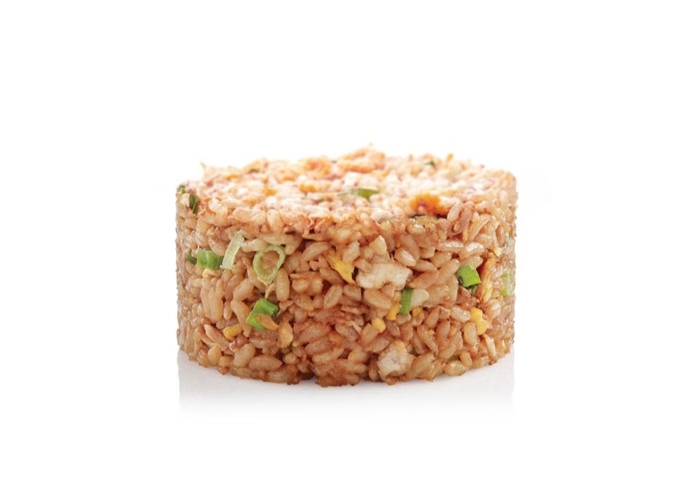 A cylindrical serving of fried rice with visible ingredients like egg and green onions on a white background.