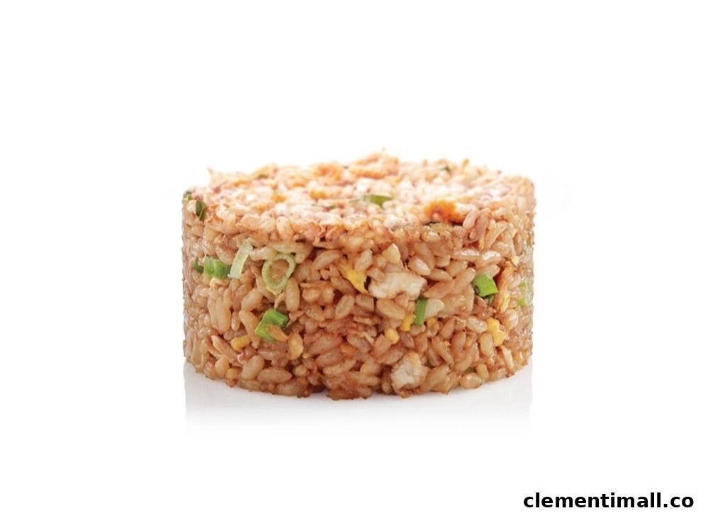 A cylindrical serving of fried rice with visible ingredients like egg and green onions on a white background.