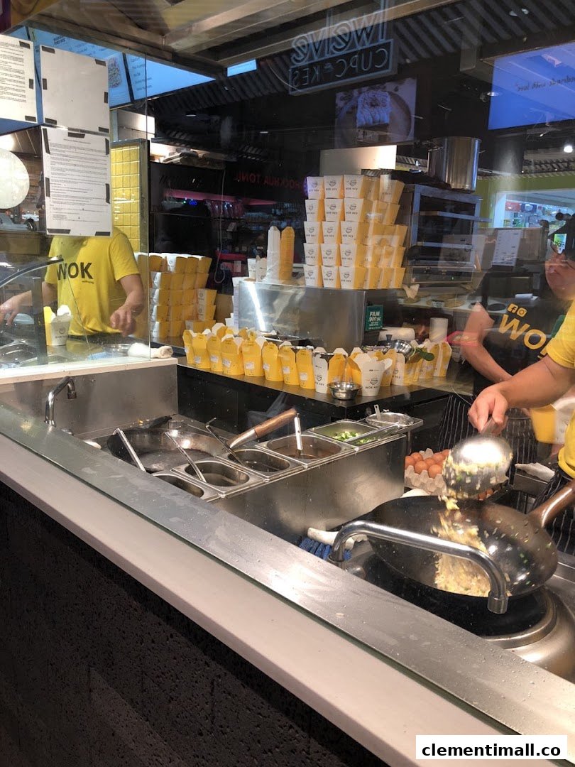 Chefs at WOK HEY prepare fresh wok-fried dishes, showcasing the open kitchen and numerous takeaway boxes.