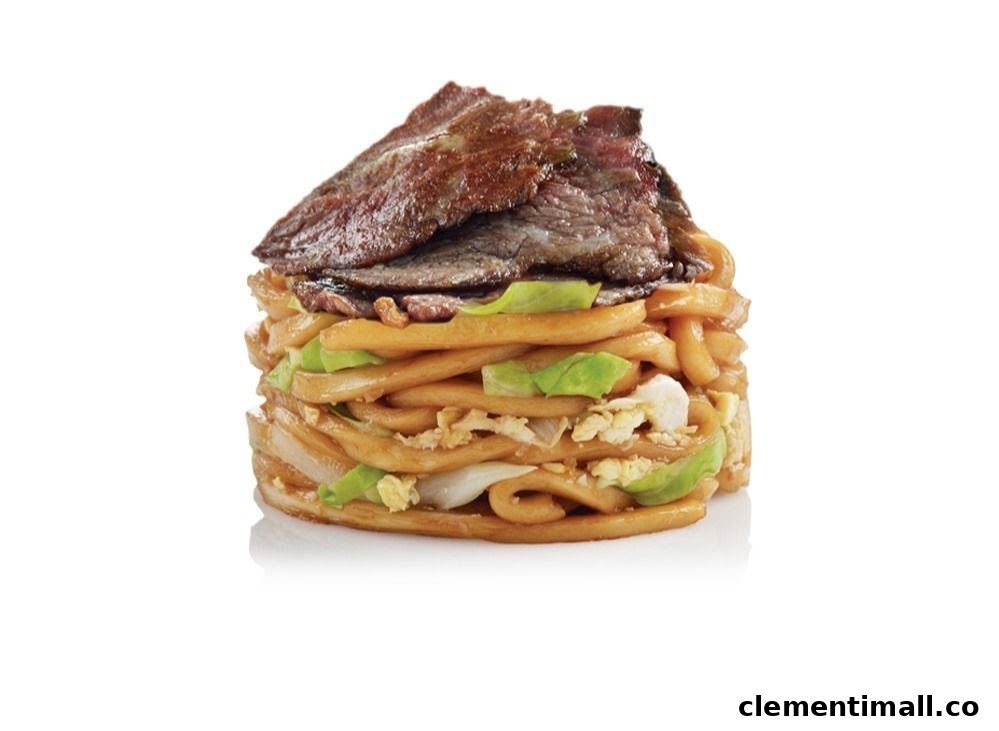 A close-up of a stacked noodle dish topped with sliced beef and vegetables.