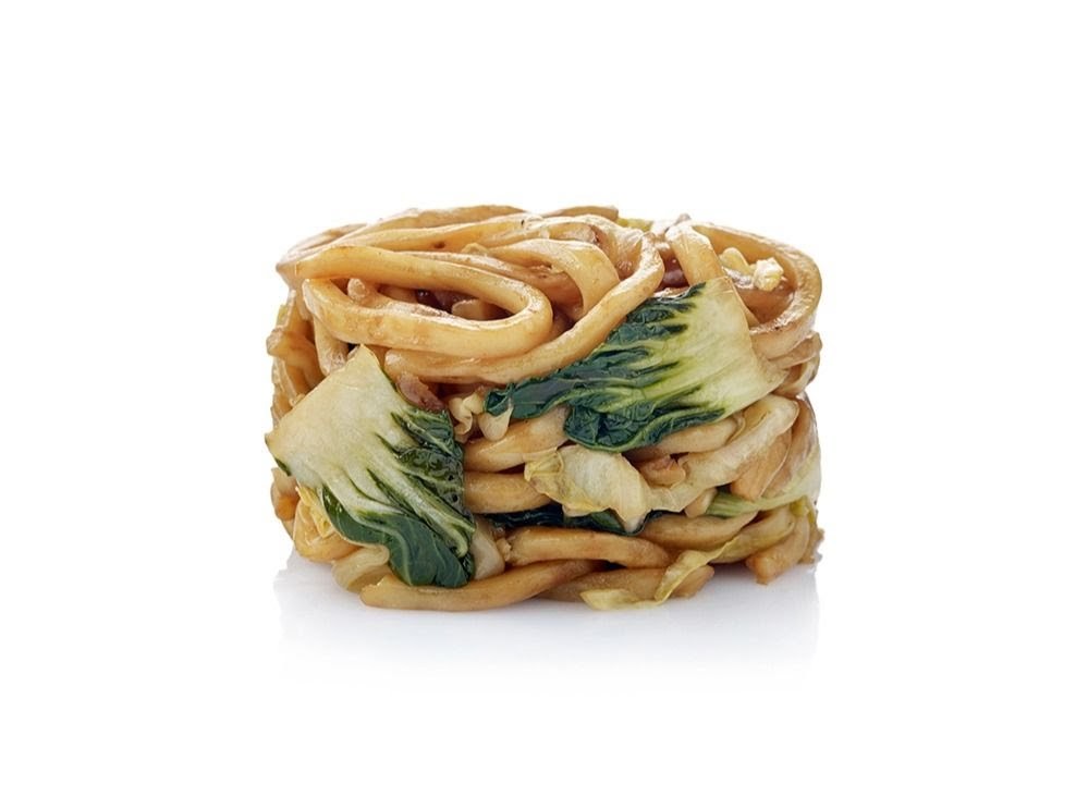 A studio shot of stir-fried noodles with bok choy, presented on a white background.
