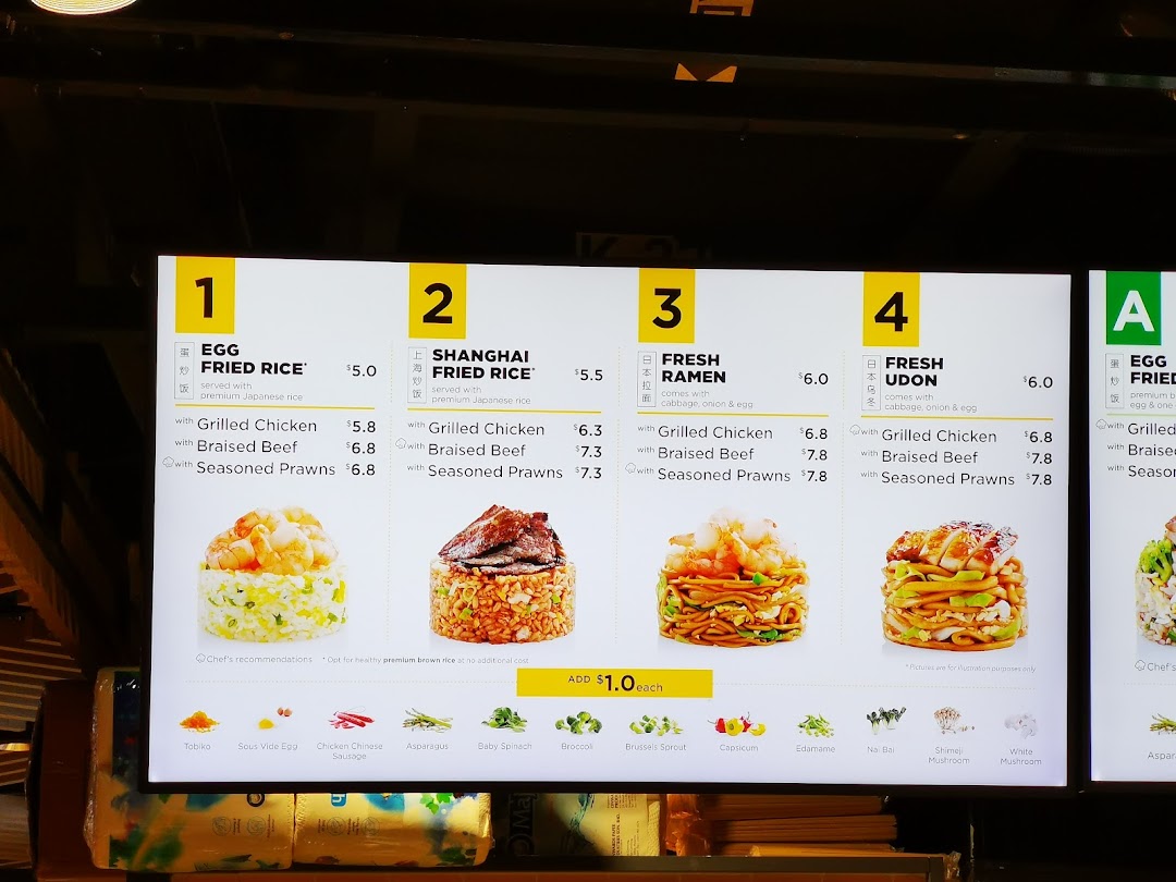 A digital menu board displaying various fried rice, ramen, and udon dishes with prices and add-ons.