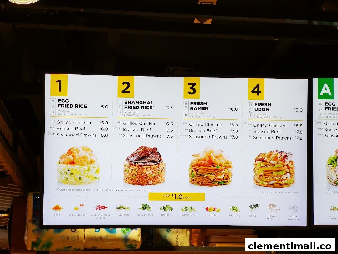 A digital menu board displaying various fried rice, ramen, and udon dishes with prices and add-ons.