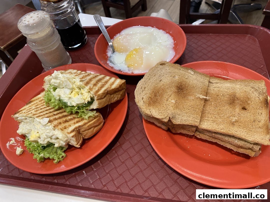 A classic Ya Kun Kaya Toast breakfast set featuring toasted bread, egg salad sandwich, and soft-boiled eggs.