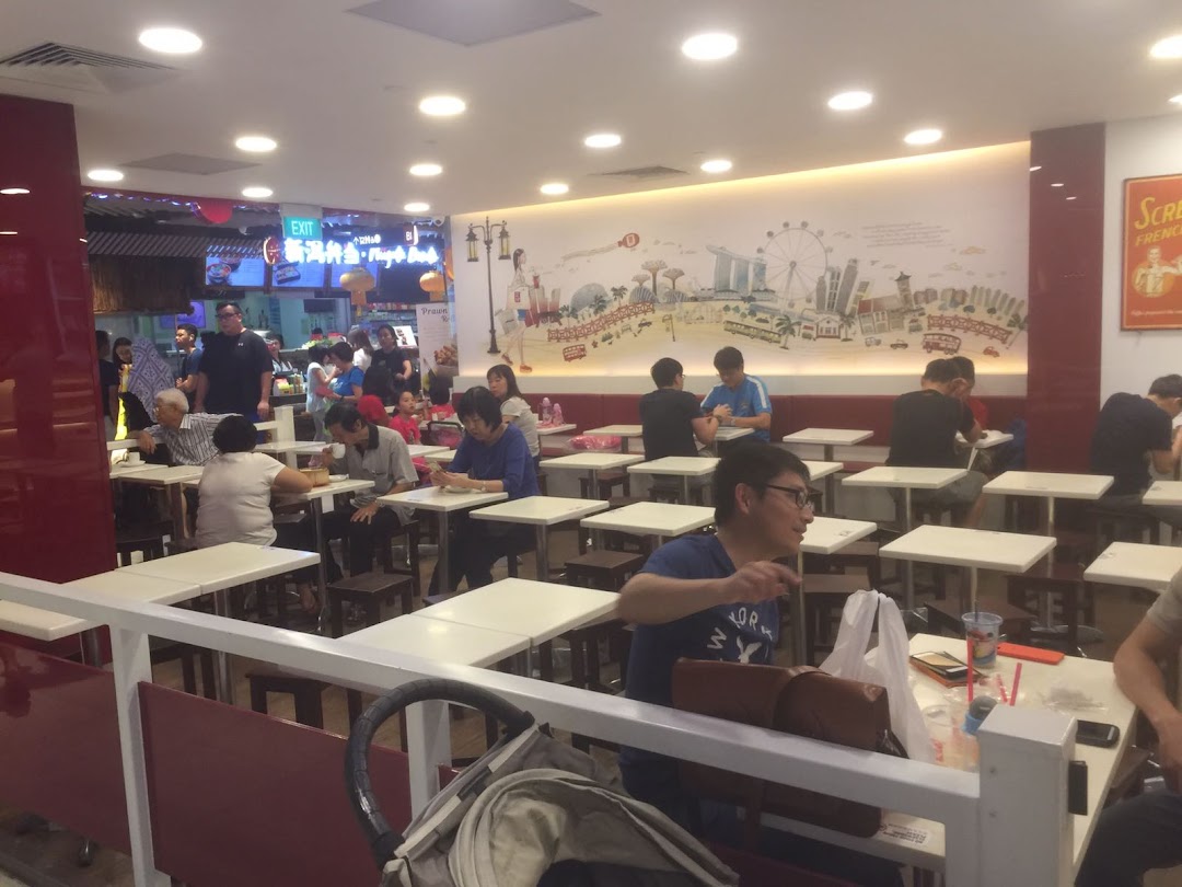 Customers enjoy meals in a brightly lit, bustling Ya Kun Kaya Toast restaurant interior with a Singapore skyline mural.
