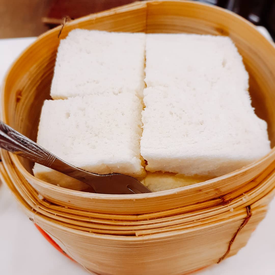 Steamed white bread served in a bamboo basket with a fork, a classic Ya Kun Kaya Toast item.