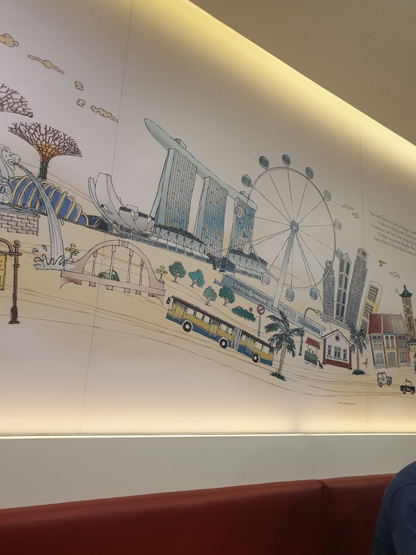 A vibrant wall mural depicting iconic Singapore landmarks inside Ya Kun Kaya Toast.