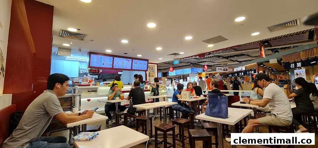 Customers enjoying meals and drinks inside Ya Kun Kaya Toast, featuring a bustling counter and dining area.