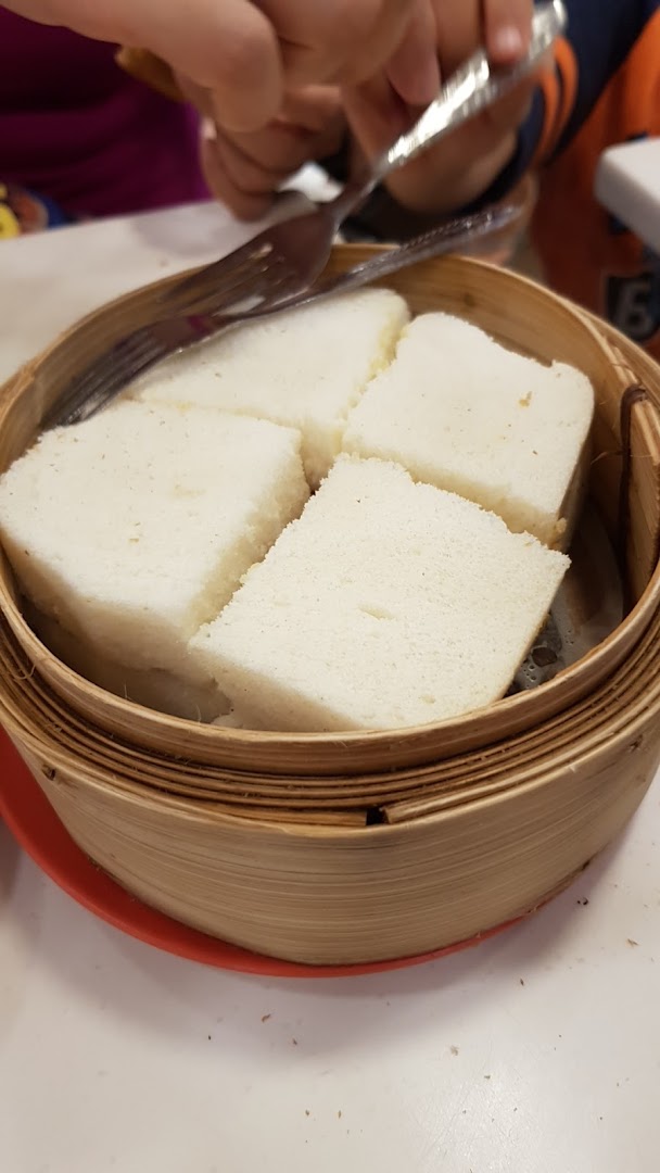 Steamed bread served in a traditional bamboo steamer at Ya Kun Kaya Toast.