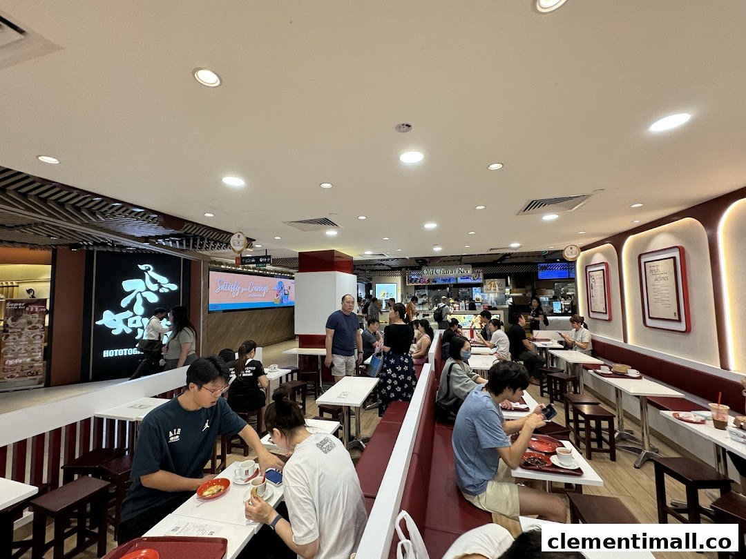 The interior of Ya Kun Kaya Toast, showing customers seated at tables enjoying their meals in a bustling setting.