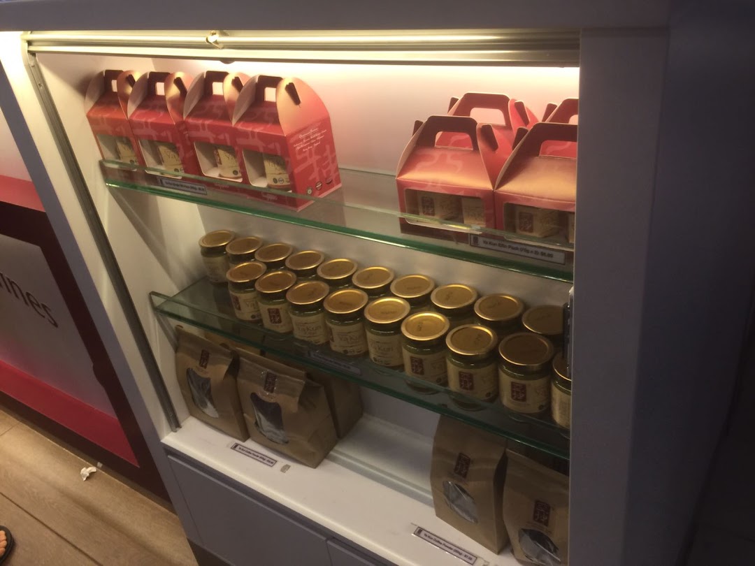 A display case at Ya Kun Kaya Toast featuring jars of kaya spread and coffee packs for sale.