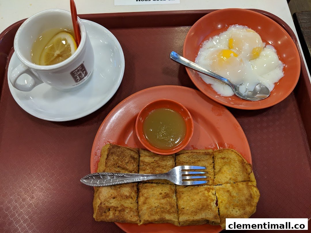A classic Ya Kun Kaya Toast breakfast set featuring kaya toast, soft-boiled eggs, and lemon tea on a tray.