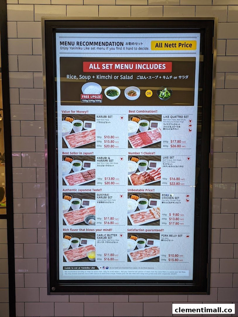 A brightly lit digital menu board displaying various yakiniku set meal options with prices and descriptions.