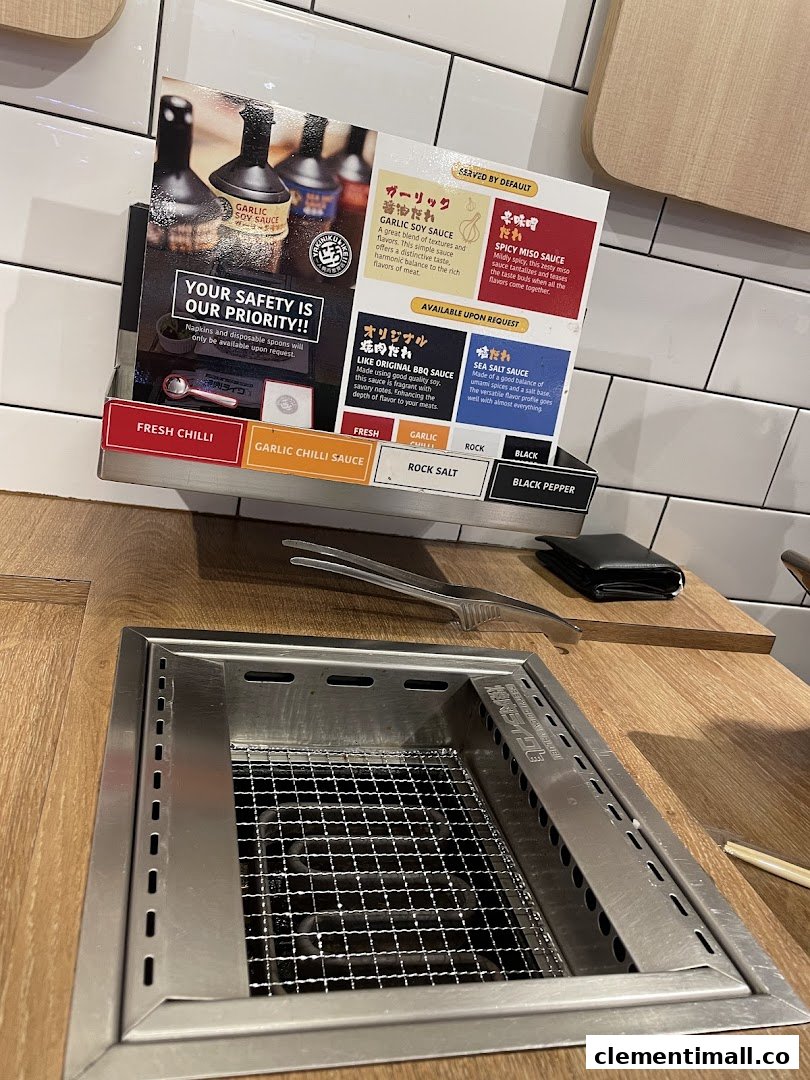 A close-up of a Yakiniku Like dining station featuring sauce and condiment options.