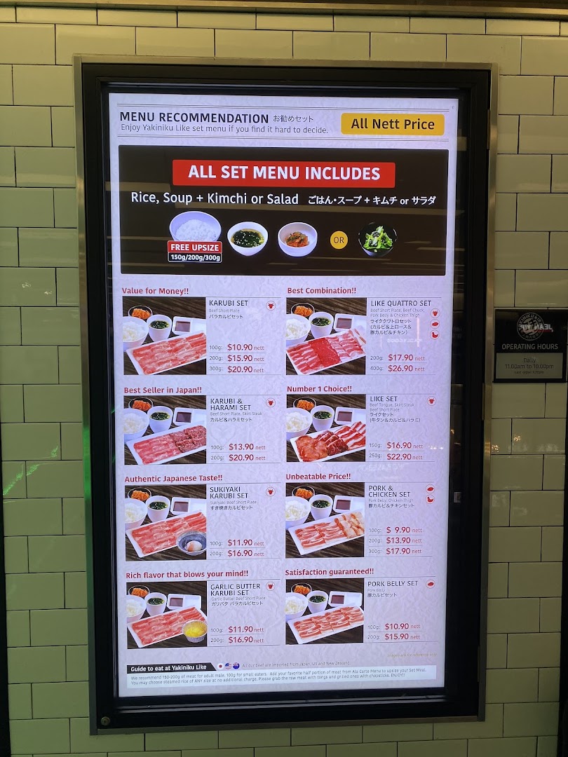 A digital menu board displaying various yakiniku set meals with prices and descriptions.