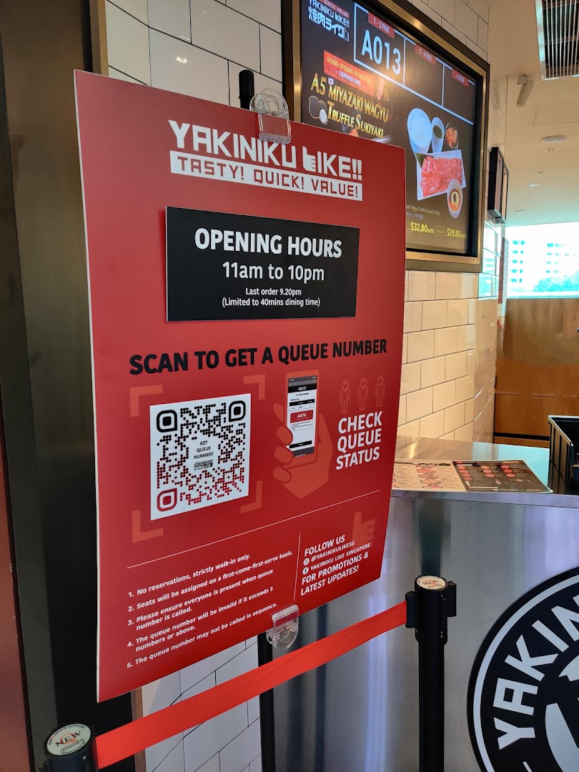 A red sign at Yakiniku Like's entrance displaying opening hours and queueing instructions.
