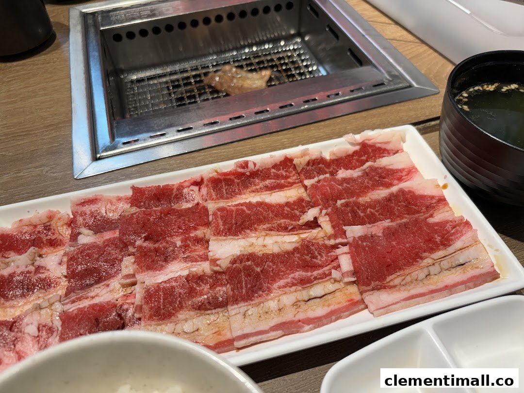 A plate of thinly sliced raw beef ready for grilling at a yakiniku restaurant table.