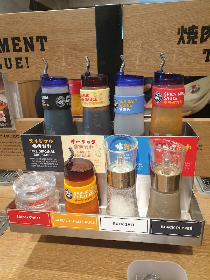 A close-up of various sauces and seasonings available at a Yakiniku Like dining table.