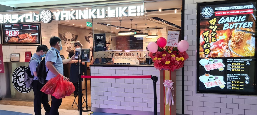 The vibrant storefront of Yakiniku Like, featuring promotional displays and customers entering.