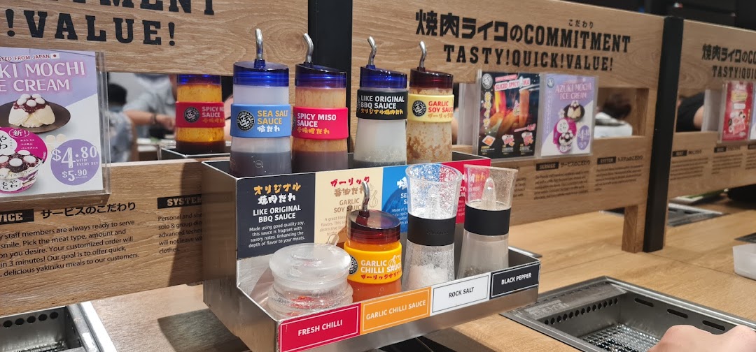 A close-up of a Yakiniku Like dining table featuring various sauces and condiments.