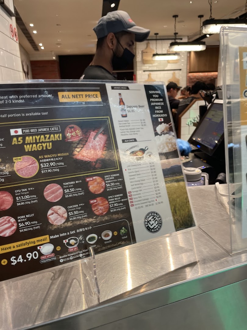 A detailed menu display showcasing various meat cuts, set meal options, and drinks at a Japanese BBQ restaurant.