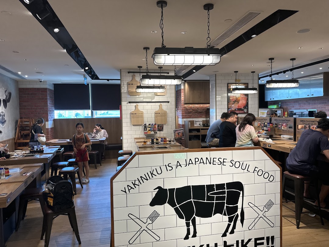 Interior view of Yakiniku Like, showing customers dining at tables and a counter, with a prominent 'Yakiniku is a Japanese Soul Food' sign.