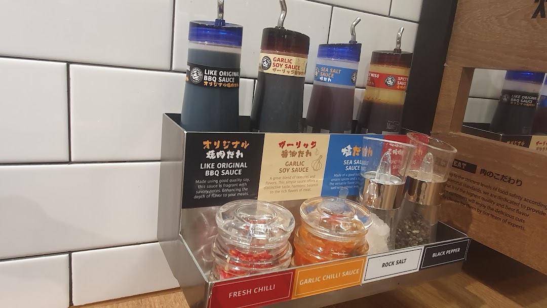 A close-up of a condiment station featuring various sauces and seasonings for yakiniku.