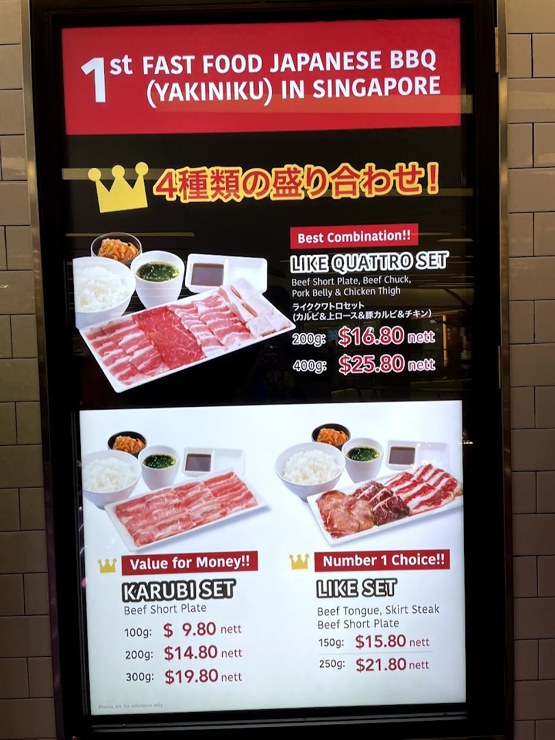 A brightly lit menu board showcasing various Japanese BBQ yakiniku sets with prices.