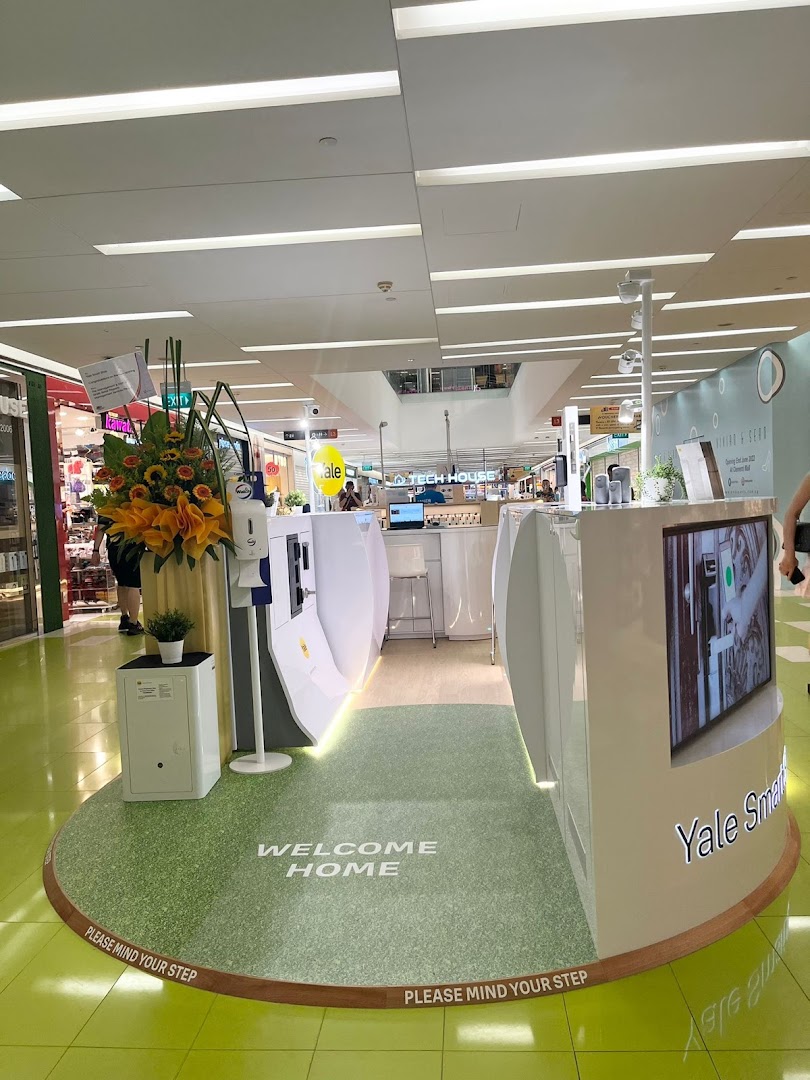 An interior view of the Yale Smart Shop display, showcasing smart home security products and a 'Welcome Home' mat.
