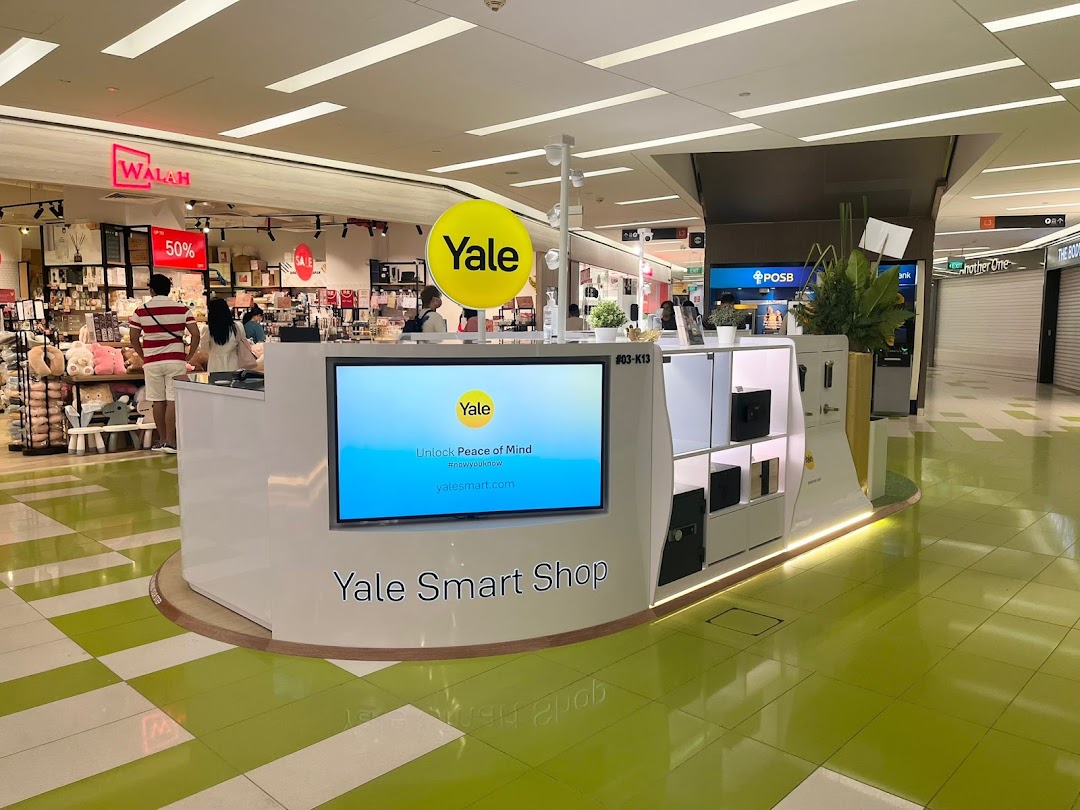 A modern Yale Smart Shop kiosk showcasing smart home security products and a digital display in a bustling mall.