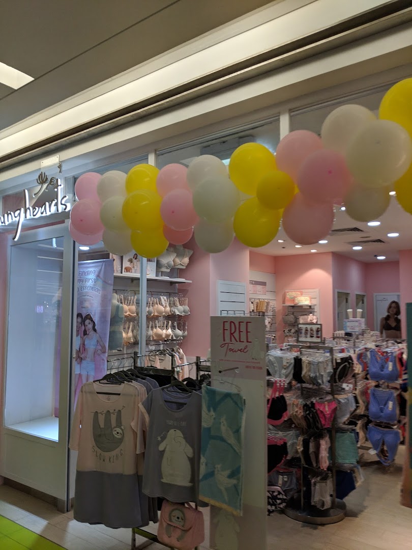 The Young Hearts shop entrance adorned with balloons, showcasing lingerie, sleepwear, and a 'Free Towel' promotion.