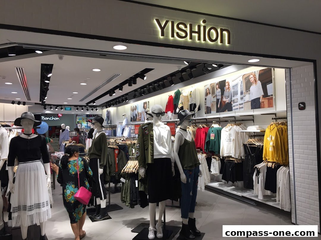 A YISHION clothing store with mannequins displaying outfits and racks of apparel.