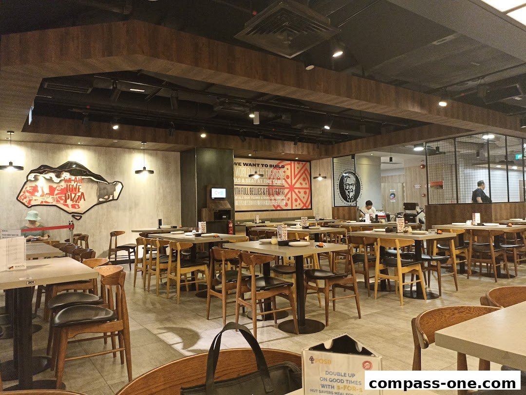 Interior view of a Pizza Hut restaurant with tables, chairs, and wall decor.