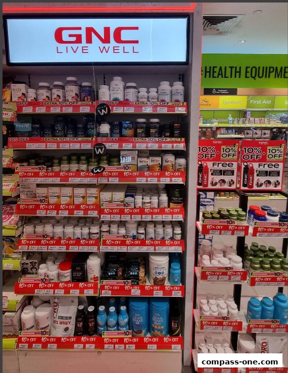 A display of GNC health supplements and products with various '10% OFF' and 'Free' promotions.