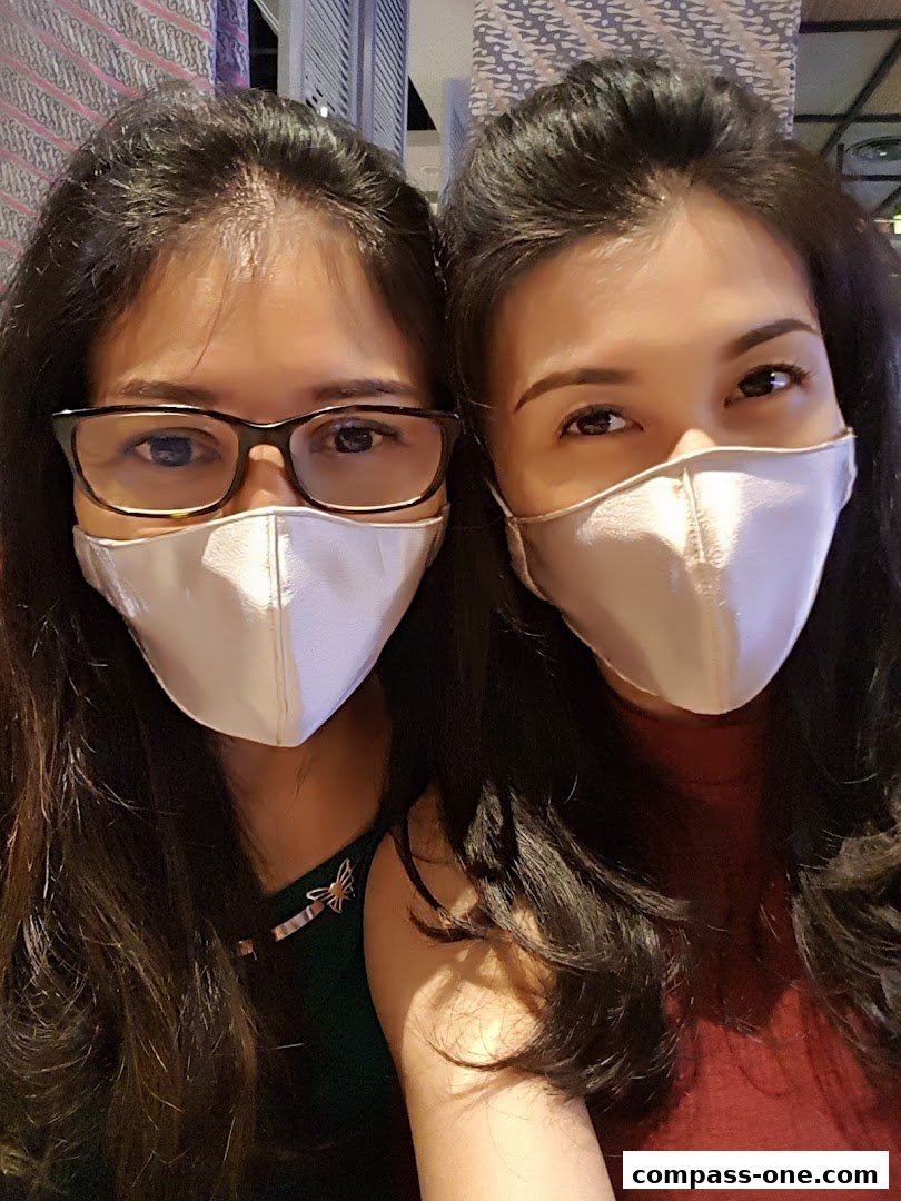 Two women wearing masks and looking at the camera.
