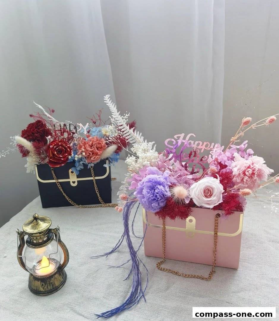 Two floral arrangements in handbag-shaped boxes with 'Happy Birthday' toppers.